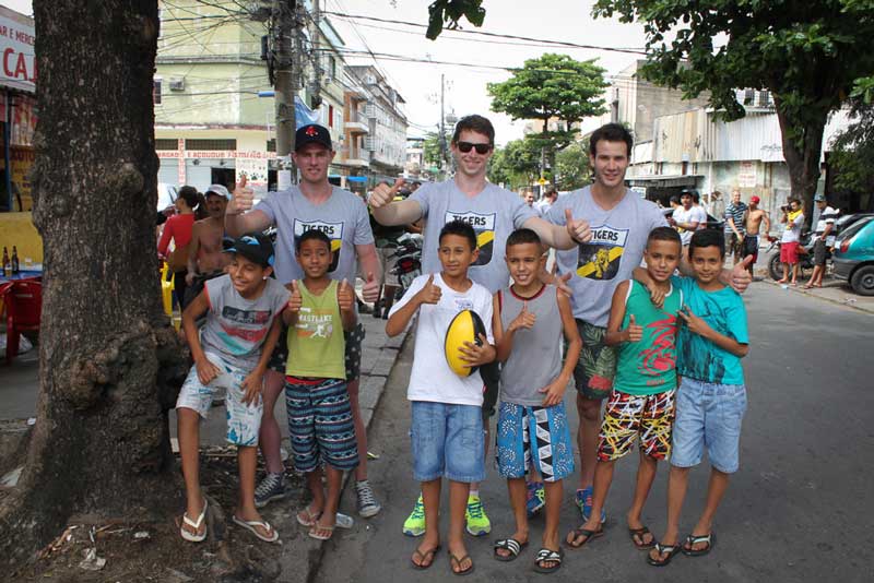 Dylan Grimes (Centre) with teammates and young Brazilian children in Rio