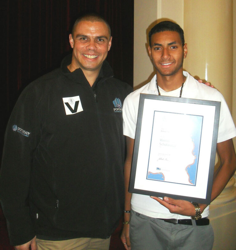 Kyle Vander Kuyp (left) presents Michael Naawi (right) with the Wannik Education Scholarship.